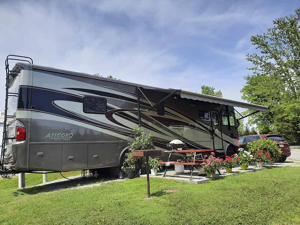 A motorhome with an open awning at KING'S HOLLY HAVEN RV PARK
