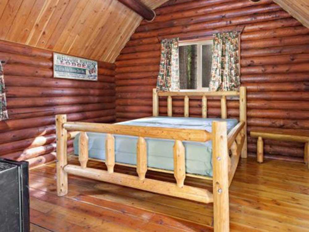 A rustic bedroom inside a rental cabin at THE NUGGET RV RESORT