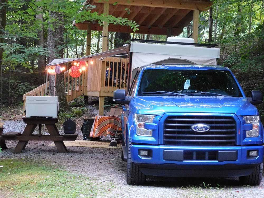 A truck and trailer in an RV site at WOODSMOKE CAMPGROUND