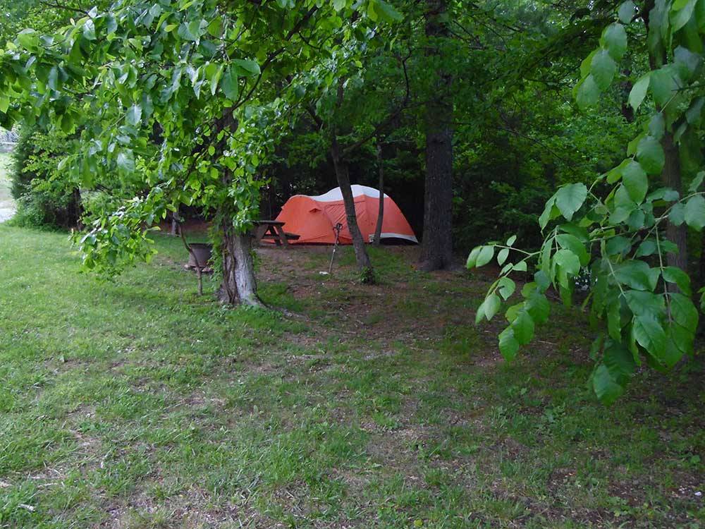 A red tent under trees at WOODSMOKE CAMPGROUND