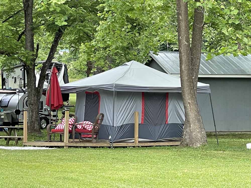 A large tent between trees at SMOKY MOUNTAIN MEADOWS CAMPGROUND