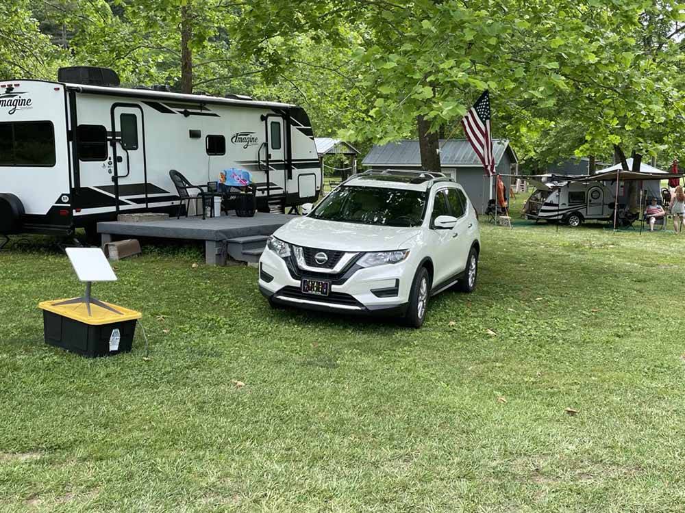 A car parked in a grassy RV site at SMOKY MOUNTAIN MEADOWS CAMPGROUND