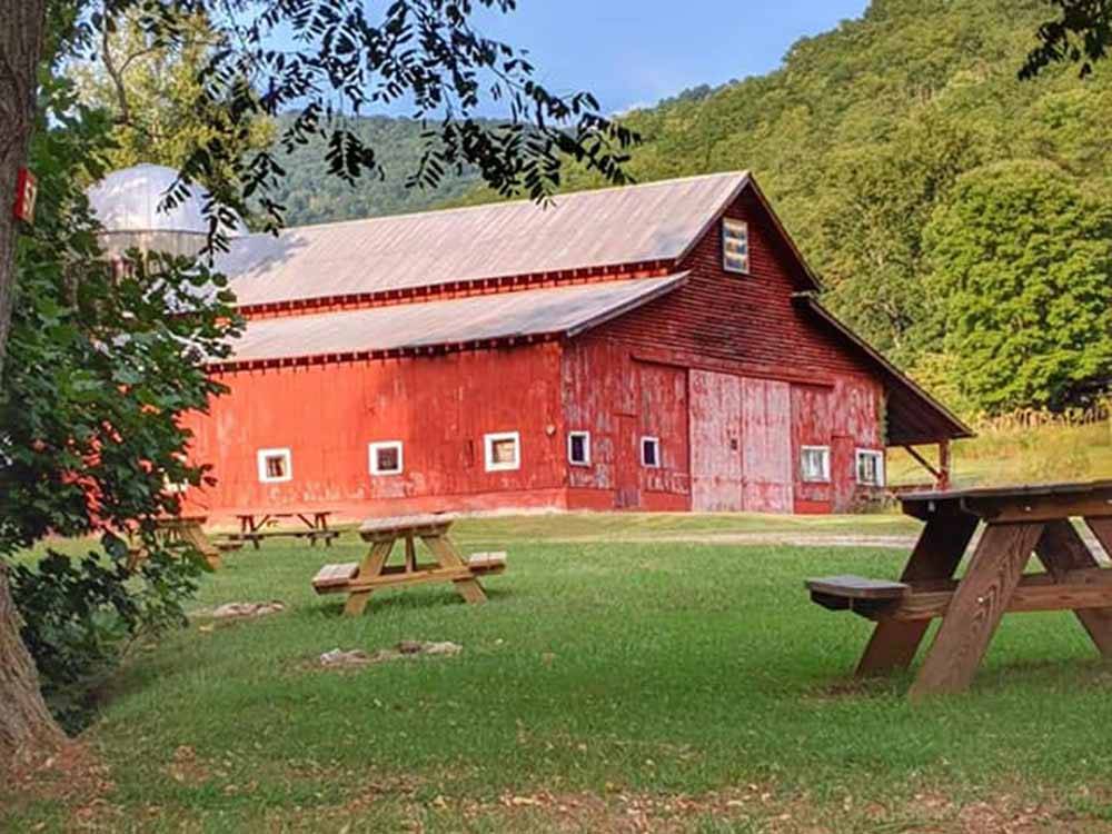 A large red barn and picnic tables at SMOKY MOUNTAIN MEADOWS CAMPGROUND