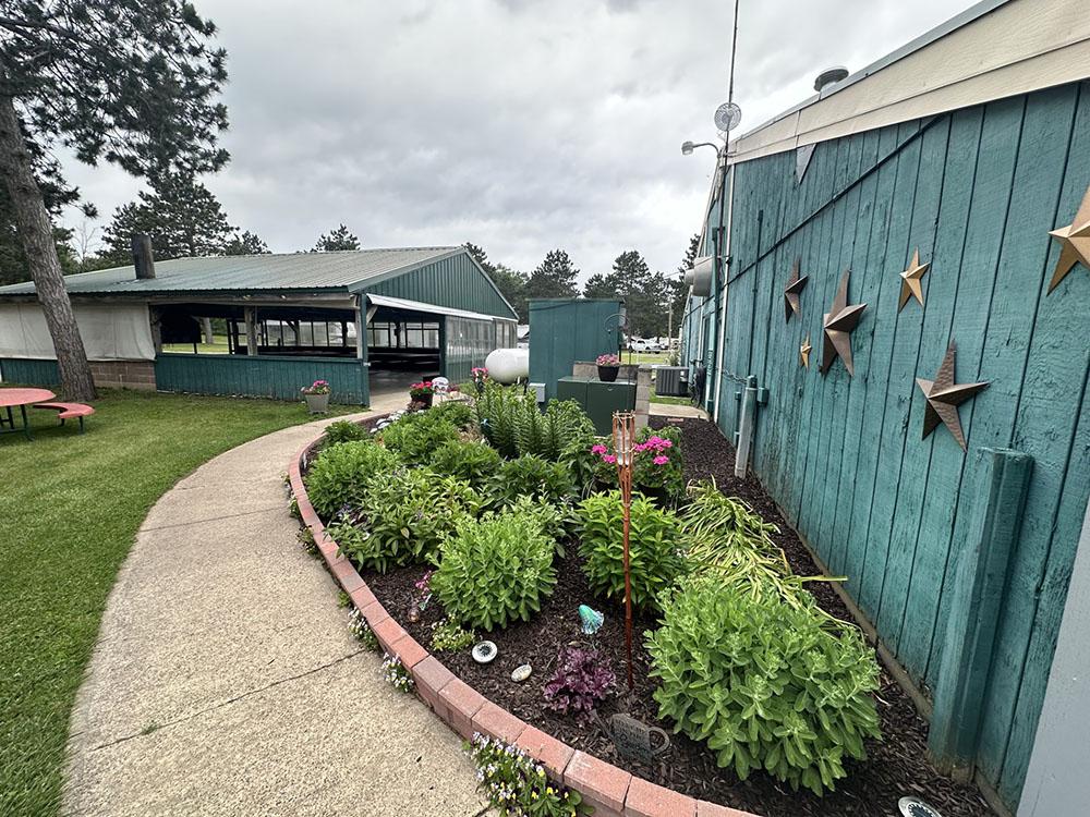 Flower bed and blue buildings at COUNTRY ROADS MOTORHOME & RV PARK