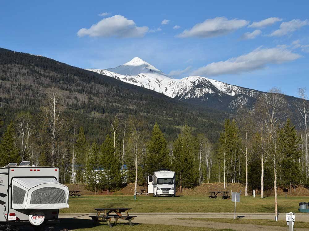 A pop-up tent and van camper parked with snow capped mountain behind at IRVIN'S PARK & CAMPGROUND