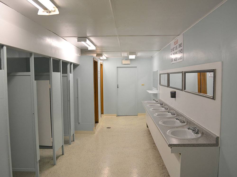 Clean bathroom with sinks and stalls at MILLER'S CAMPING RESORT