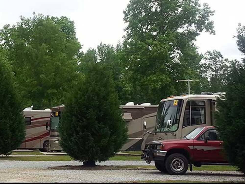 Red and tan truck and RV backed in at site at LAKE PINES RV PARK & CAMPGROUND
