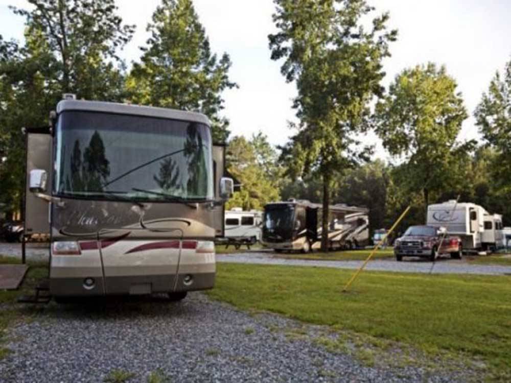 A motorhome in a gravel RV site at LAKE PINES RV PARK & CAMPGROUND
