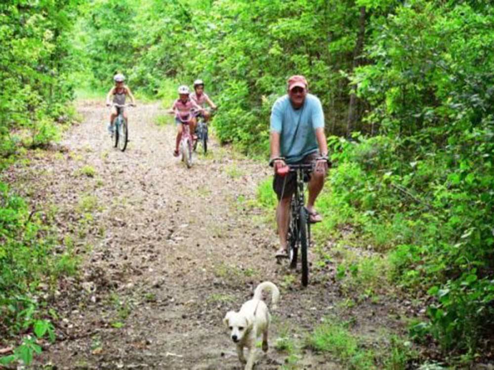 A family biking on a path at LAKE PINES RV PARK & CAMPGROUND