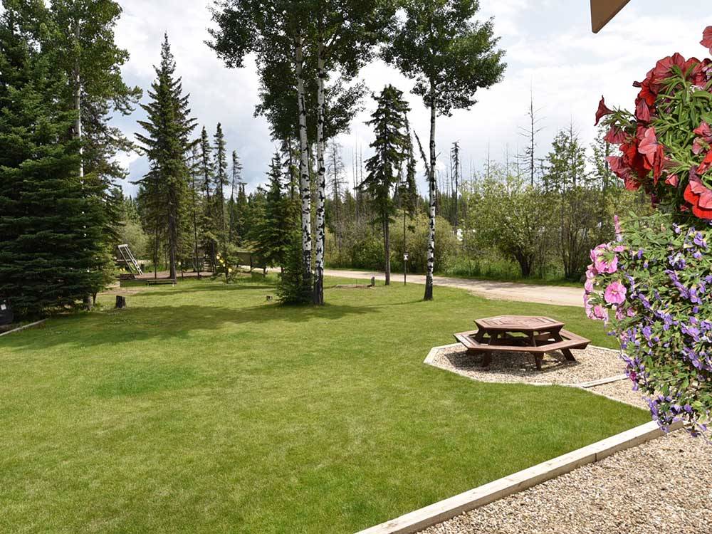 A green grassy area with a wooden table at CAMP TAMARACK RV PARK