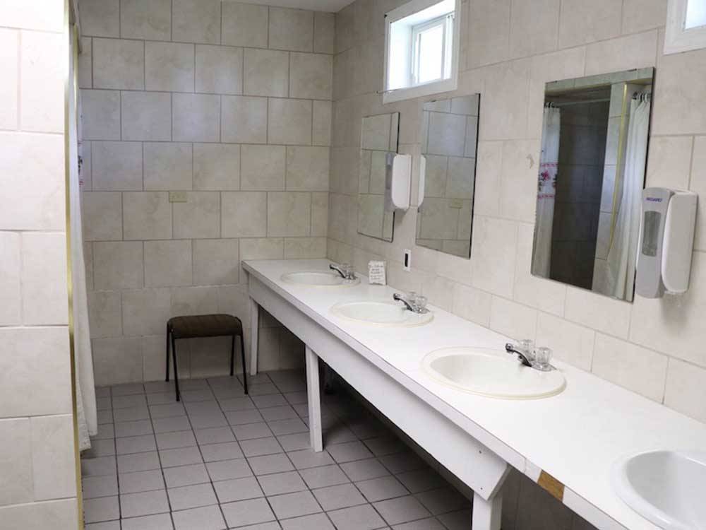 Row of sinks in public bathroom at COUNTRY ROADS RV PARK