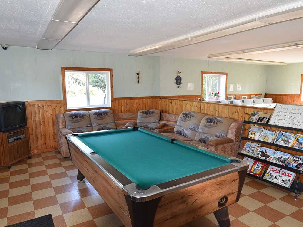 The pool table with games and magazines on the rack at COUNTRY ROADS RV PARK