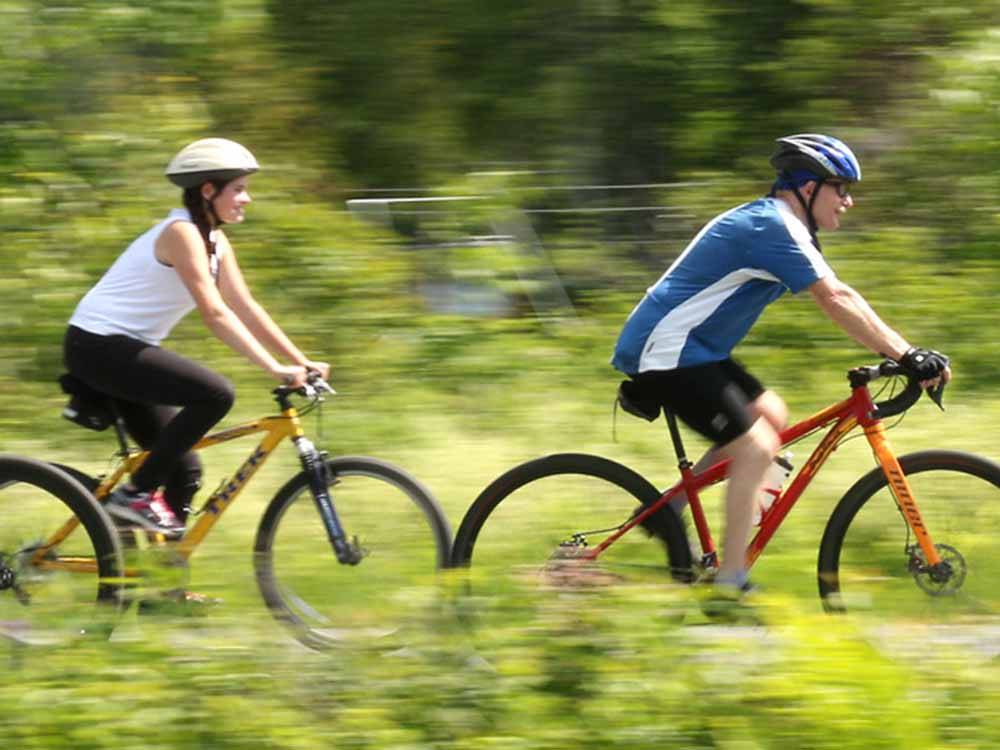 A couple riding mountain bikes at SUGAR RIDGE RV VILLAGE & CAMPGROUND