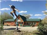 View larger image of View of office behind statue of dancing native american at MESA VERDE RV RESORT image #6