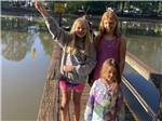 Three girls on the pier and one showing her fish at GREEN ACRES FAMILY CAMPGROUND - thumbnail