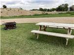 A picnic table and fire pit by a RV site at RUBY VALLEY CAMPGROUND & RV PARK - thumbnail