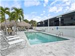 Lounge seating and tiki hutches by the pool - thumbnail