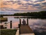 A man sitting in a chair on the pier fishing at UPRIVER RV RESORT - thumbnail