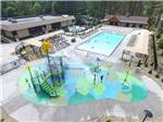 View larger image of Aerial view of colorful splash pad alongside large community pool at LAKE GEORGE RV PARK image #7