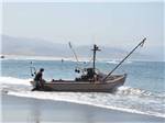 A fishing boat that is washed up on the shoreline at CAPE KIWANDA RV RESORT & MARKETPLACE - thumbnail