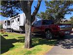 A fifth wheel and a pickup truck parked in an RV spot at CAPE KIWANDA RV RESORT & MARKETPLACE - thumbnail