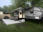 Travel trailer with awnings over seating at Hide-A-Way Campground - thumbnail