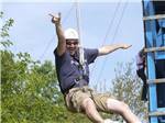 A man having fun on a zip line at INDIAN CREEK CAMP & CONFERENCE CENTER - thumbnail