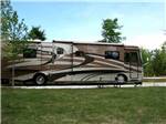 View larger image of Tan Class A motorhome parked in gravel site at LAKESIDE RV PARK image #3