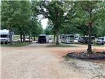 A row of motorhomes and trailers parked in gravel sites at LAKESIDE RV PARK - thumbnail