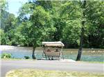 Couple sitting by the water at CASEY'S RIVERSIDE RV PARK - thumbnail