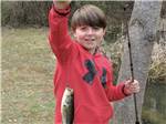 View larger image of A kid holding a fish at CAMPFIRE LODGINGS image #7