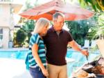 A couple barbecuing by the pool at SAN DIEGO RV RESORT - thumbnail