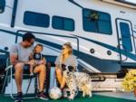 A family with their dog next to the trailer at SAN DIEGO RV RESORT - thumbnail