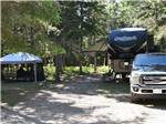 Camper and screened tent in campsite at WAWA RV RESORT & CAMPGROUND - thumbnail