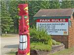 Red totem pole in front of sign listing Park Rules at WAWA RV RESORT & CAMPGROUND - thumbnail