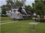 A Class A motorhome pulled in to a gravel site at BUSHMAN'S RV PARK - thumbnail
