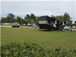 A fifth wheel parked next to the volleyball court at BUSHMAN'S RV PARK - thumbnail