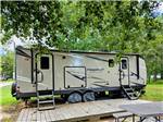 A tan travel trailer parked at a site at Taw Caw Campground & Marina - thumbnail