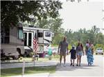 A family walking down a paved road at Bayberry RV Park - thumbnail