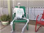 A fake skeleton sitting in a chair at THE SCENIC ROAD RV PARK - thumbnail