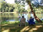 Couple sitting by the water at WATERSIDE CAMPGROUND & RV PARK - thumbnail