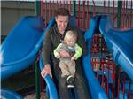A man and child on the playground equipment at DELLANERA RV PARK - thumbnail