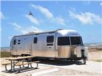View larger image of An airstream trailer parked next to a picnic table at DELLANERA RV PARK image #9