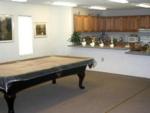 Indoor rec hall with kitchen and billiard table at SWEET GUM MOBILE HOME AND RV COMMUNITY - thumbnail