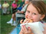 View larger image of Girl eating a Smores at the campsite at TURTLE BEACH image #6