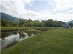 View larger image of Campground with mountains on the horizon at COVE CREEK RV RESORT image #10