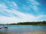 A boat docked at the pier with a swing set in the water at Ham Lake Resort - thumbnail