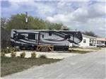 A fifth wheel in a back in RV site at HOOVES N' WHEELS RV PARK & HORSE MOTEL - thumbnail