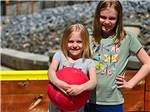 A couple of kids holding a red ball at STONYBROOK RV RESORT - thumbnail