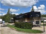 A motorhome parked in a gravel site at CAMP 'N CLASS RV PARK - thumbnail